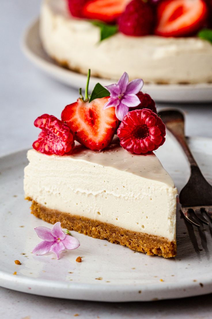 a piece of cheesecake with strawberries on top and a fork next to it