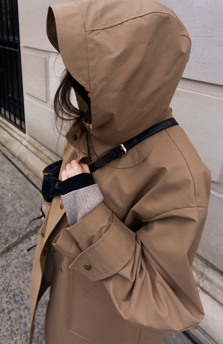 Fabric: 73% Cotton, 27% NylonColor: Light BrownCare: Hand wash / Dry clean Waterproof oversized hooded trench coat with two front pockets and centre front bottom closure. The length is 46-47 inches (118-120 cm). Unlined. Consider wearing at a temperature 68-50°F (20-10°C) Made in USA. Oversized Hooded Raincoat For Work, Parka With Detachable Hood For Cold Weather, Winter Long Coat For Rainy Weather, Long Winter Parka For Rainy Weather, Cold Weather Hooded Raincoat With Double-lined Hood, Oversized Parka With Adjustable Hood For Cold Weather, Oversized Beige Outerwear With Detachable Hood, Fall Utility Parka For Rainy Weather, Fall Travel Parka With Detachable Hood