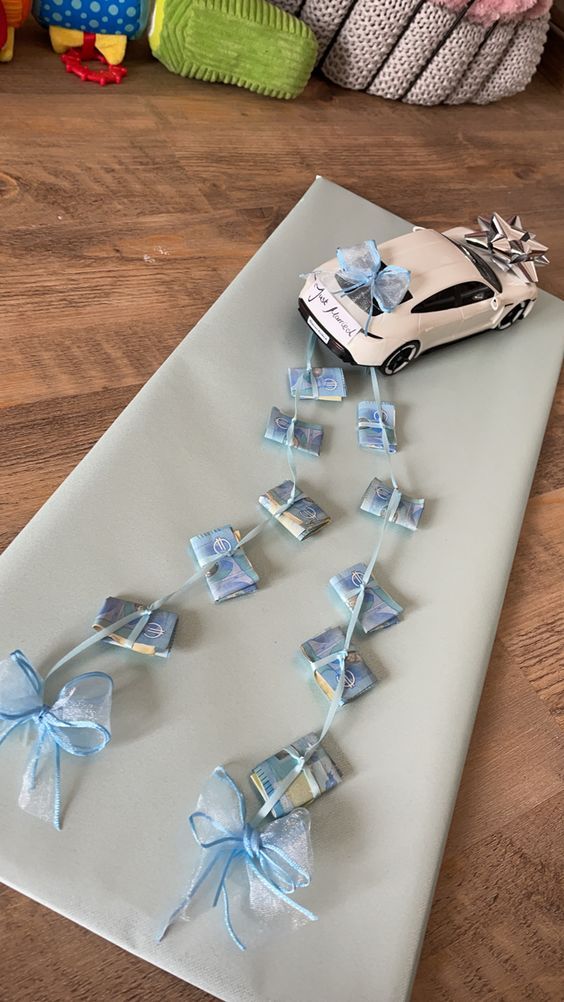 a car is sitting on top of a mat with blue bows and ribbons attached to it