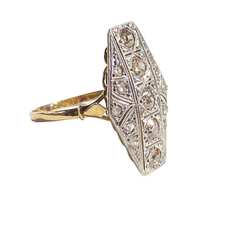 This exceptional Art Deco ring from circa 1920 features a rare 18 K yellow gold mounting with 1.5 mm shanking. It boasts a 24 x 15 fared shield adorned with 15 diamonds, 10 rose cuts 1.4 to 1.6 mm (1.5 to 2 points) and 5 old European cuts 3.1 mm (12 points). The diamonds have KT colors and VS clarities, with a total weight of 15 points. The gold weight is 2.1 dwt (3.26 grams). Classic Octagon Diamond Ring With Accents, Antique Diamond Accented Signet Ring, Art Deco Diamond White Ring With 17 Jewels, Yellow Gold Oval Diamond Ring In Art Deco Style, Art Deco Yellow Gold Oval Diamond Ring, Classic Octagon Ring With Diamond Accents, Antique Marquise Yellow Gold Diamond Ring, Art Deco Diamond Ring With Pave Setting, Heirloom Baguette Cut Diamond Ring With Rose Cut Diamonds