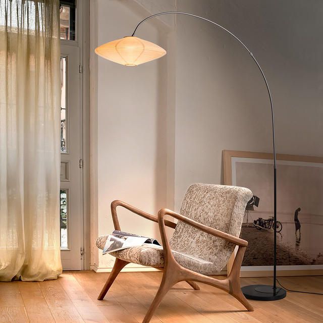 a living room with a chair and a floor lamp