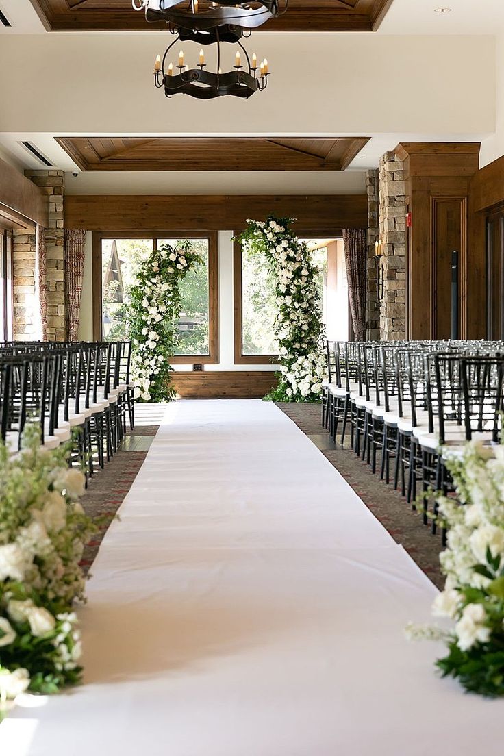 the aisle is lined with chairs and flowers