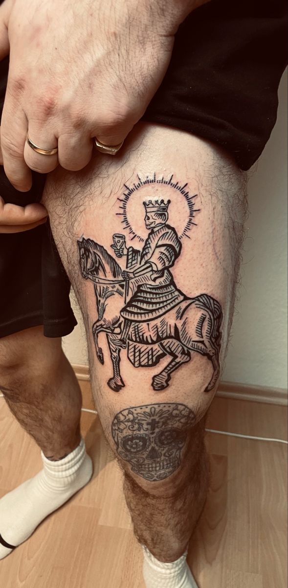 a man's leg with a tattoo on it and a knight riding a horse