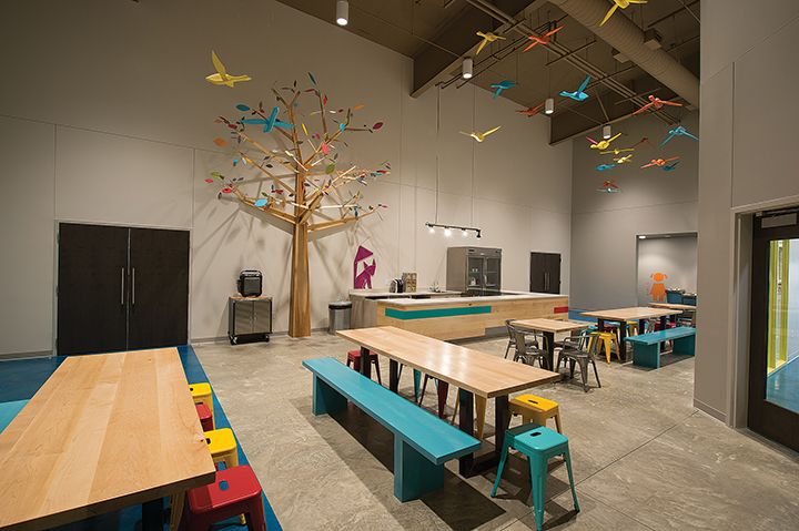 an empty classroom with tables, benches and colorful decorations