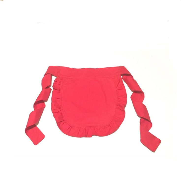 a small red bag with ruffles on the front and bottom, sitting on a white surface