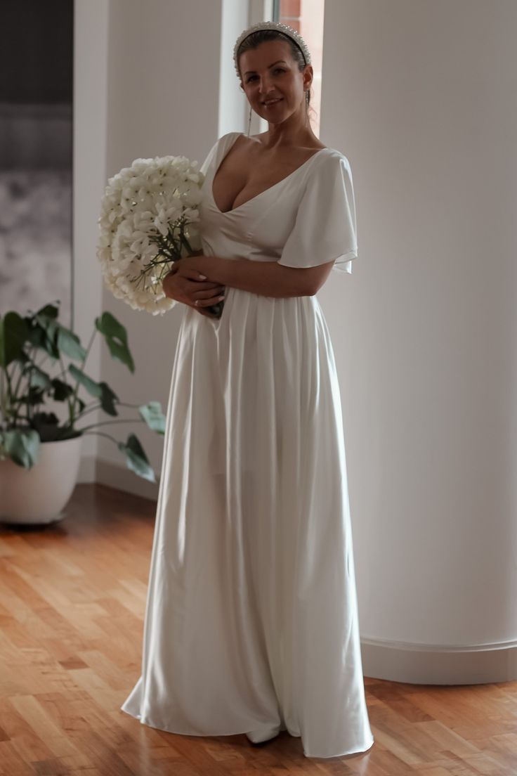 a woman in a white dress holding a bouquet of flowers