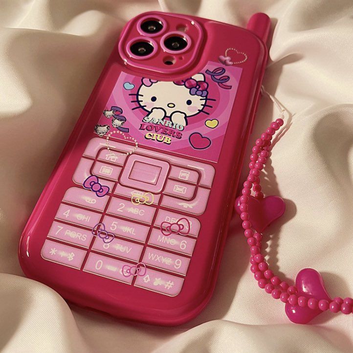 a pink cell phone sitting on top of a bed next to a beaded necklace