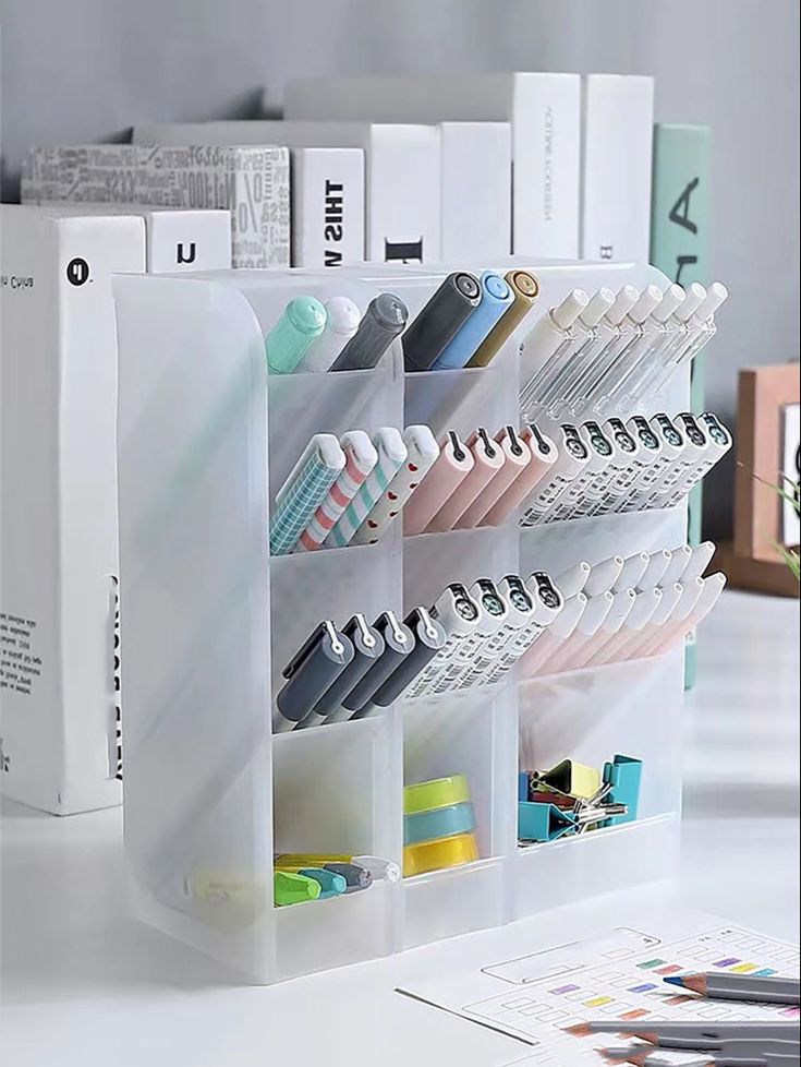 an office desk with various pens, pencils and markers on the shelf in front of it