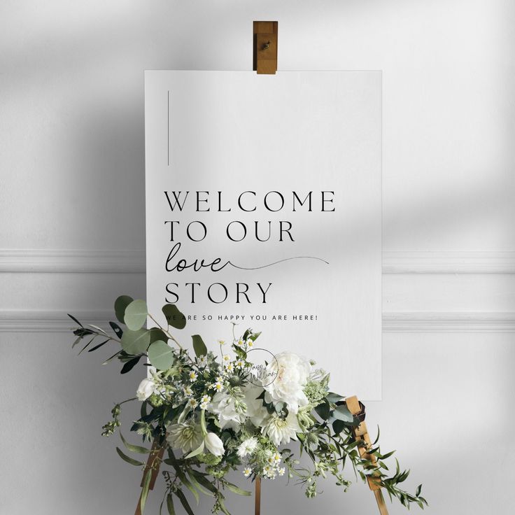 a welcome sign with white flowers and greenery