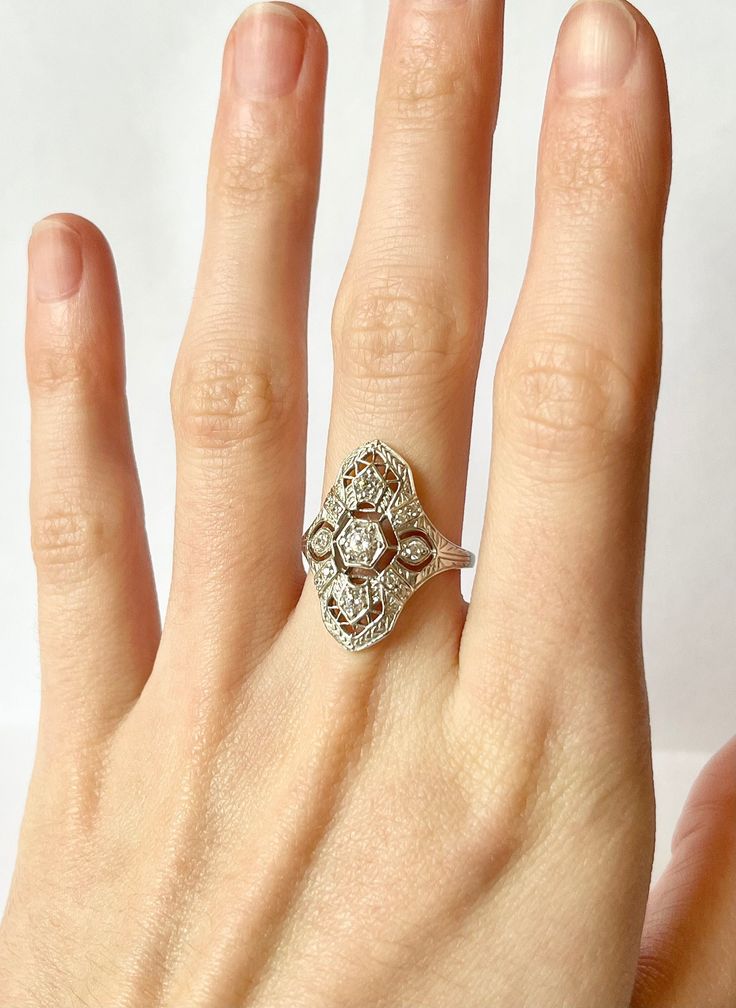 Once in a Blue Moon vintage finds! Art Deco Filigree Ring // Antique Remake Contains a total of 12 flawless CZ gemstones in an art deco geometric setting.  Size:  5-10 US Metal purity: Solid 925 Sterling Silver Weight: 2.6 g Band width: 2.0 mm Free Shipping, comes in ring box ready to gift! ~Why Cubic Zirconia?~ CZ is a lab created stone with the closest resemblance to Diamond. In recent years, developers have succeeded in adding color to CZ, making it an affordable alternative to almost any gem Classic Hand Set Cubic Zirconia Diamond Ring, Heirloom Adjustable Diamond Cut Ring, Hand Set Diamond Ring For Anniversary, Art Deco Jewelry With Rose Cut Round Diamonds, Art Deco Diamond Accented Jewelry For Wedding, Art Deco Style Oval Cluster Ring As Gift, Vintage Round Jewelry With Diamond Accents, Art Deco Rose Cut Round Diamond Jewelry, Art Deco Open Ring For Anniversary