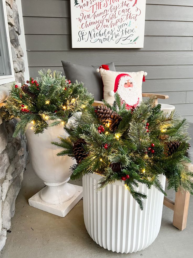 a white planter filled with pine cones and christmas lights