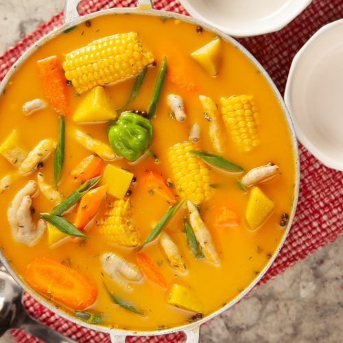 a pot filled with soup and vegetables on top of a table