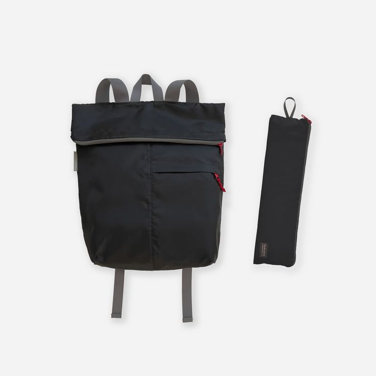 a black backpack with two straps and a pouch next to it on a white background