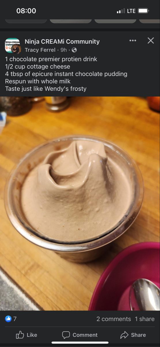 a bowl filled with cream sitting on top of a wooden table