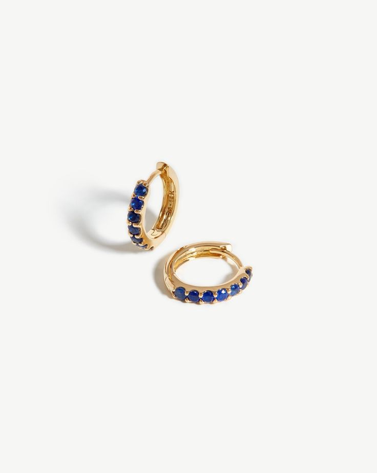 Fine Sapphire Huggies 14ct Solid Gold/Sapphire. Everyday Huggies, Elevated. These Mini Hoop Earrings are Inset with Blue Sapphires and Open with a Hinge. Pair with 14Ct Solid Gold Huggies for a Refined Ear Stack. Crafted from 100% Recycled Gold, and Hallmarked for Authenticity. Metal: 14Ct Recycled Solid Gold Gemstone: Blue Sapphire, with Quality 0. 56Ct Dimensions: 11mm X 2. 07mm Weight: 1. 4g this Piece is Handcrafted with Recycled Metal Elements to Help us Reduce Our Environmental Impact. Pro Gold Huggies, Double Chain Bracelet, Malachite Necklace, Chain Belts, Ear Stack, Mini Hoop Earrings, Recycled Jewelry, Pearl Pendant Necklace, Recycled Metal