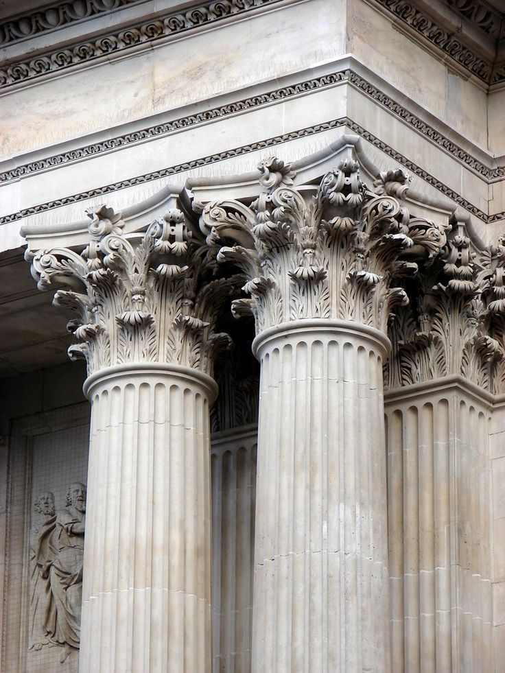 an old photo of some pillars in front of a building