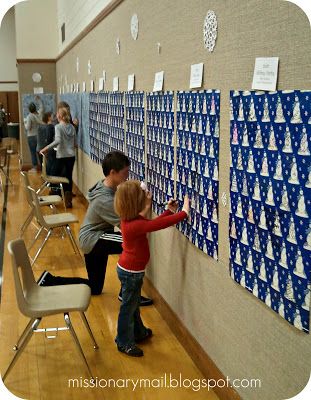 two children are writing on the wall with blue and white christmas decorations in front of them