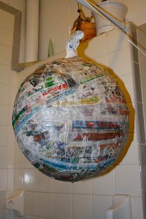 a large ball with stickers on it hanging from the side of a shower head