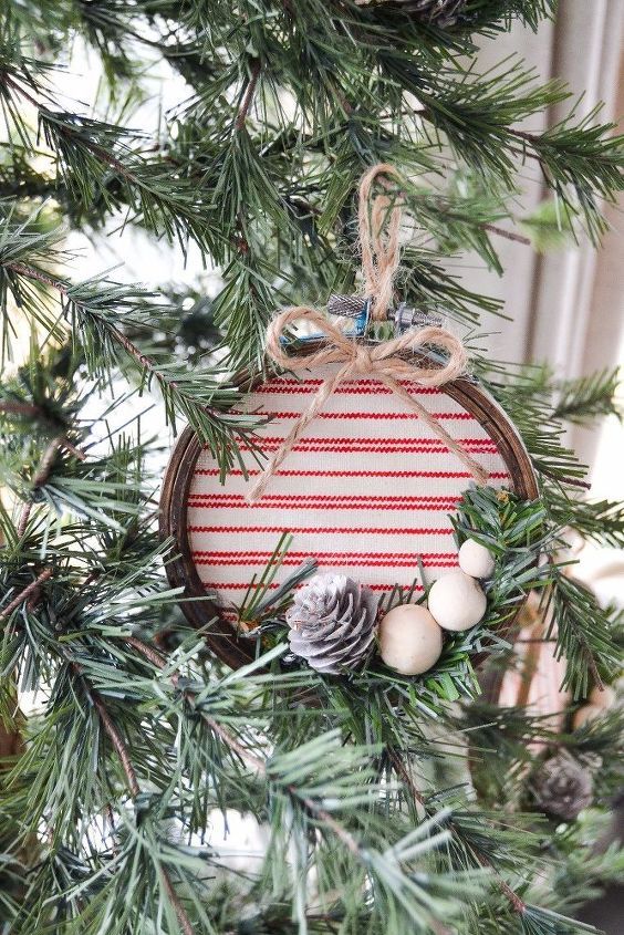 a christmas ornament hanging from a tree with pine cones and balls on it