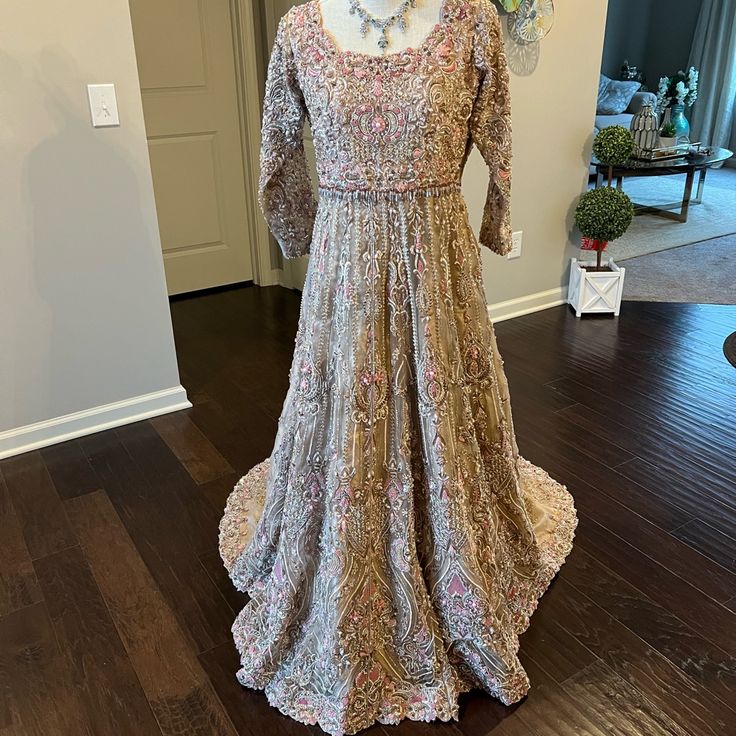 Hi, This Is A Beautiful Brand New Designer Piece, Perfect To Wear For An Engagement, Nikkah, Or Walima. I Will Consider All Offers! Thanks For Looking! Gold/ Beige Fabric With Gold/Silver/Pink Handwork Measurements For Dress: Shoulders: 15” Bust: 18” Waist: 17” Hips: 22” Dress Length: 65” From Front Side Pink Naqshi Lehenga, Designer Gown With Naqshi In Traditional Drape, Designer Wear Gown With Naqshi In Traditional Drape, Bollywood Style Gown With Naqshi For Reception, Pink Naqshi Lehenga For Wedding, Eid Reception Dress With Naqshi Detailing, Naqshi Dresses For Eid Reception, Elegant Reception Gown With Naqshi Detailing, Elegant Gown With Naqshi For Reception