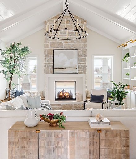 a living room filled with furniture and a fire place in the middle of a room