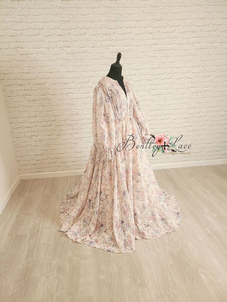 Our beautiful “Sarah” gown is the perfect mix of boho and vintage inspiration. Her silhouette is made of a beautiful pink floral chiffon. We have added a modest neckline - perfect for those seeking more coverage. This dress comes lined. This gown does have a closed bodice. It is important to consider the shoulder to shoulder measurements. We have added an elastic waistband which lends to its ease of size adjustment. Please note: this fabric is delicate. Please be cautious around sharp objects. T Feminine Pink Gown With Floral Print, Bohemian Floor-length Gown With Floral Print, Pink Bohemian Maxi Dress For Wedding, Bohemian Flowy Chiffon Floral Dress, Flowy Bohemian Chiffon Floral Dress, Flowy Floral Maxi Dress For Wedding, Bohemian Floor-length Pink Gown, Bohemian Pink Floor-length Gown, Flowy Feminine Floral Dress For Wedding