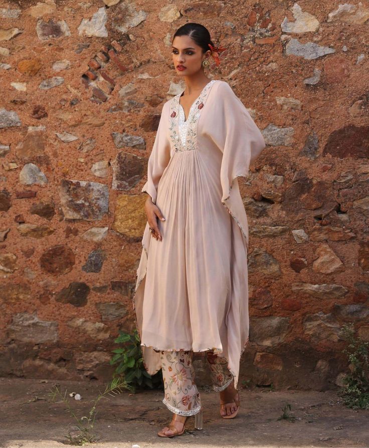 Step into luxury with this embellished kaftan featuring exquisite appliqué work on the neckline, perfectly paired with embellished printed pants. This ensemble marries intricate detailing with vibrant prints, offering a perfect balance of elegance and style. Ideal for special occasions or evenings out, it promises to make a statement with its unique design. Anarkali Set With Embroidered Neckline, Festive Designer Anarkali Set With Embroidered Neckline, Bollywood Style Anarkali Set With Embroidered Neckline For Eid, Traditional Anarkali Set With Embroidered Neckline For Eid, Traditional Eid Anarkali Set With Embroidered Neckline, Festive Bollywood Anarkali Set With Embroidered Neckline, Festive Anarkali Dupatta With Embroidered Neckline, Festive Dupatta With Embroidered Neckline For Eid, Wedding Salwar Kameez With Embroidered Neckline For Eid