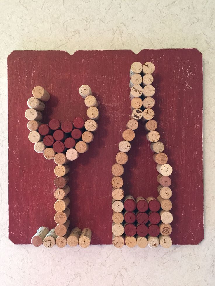 the word love spelled with wine corks on a red board