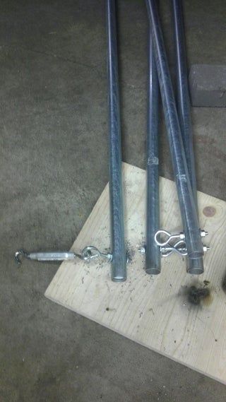 three pieces of metal sitting on top of a piece of wood next to a wrench