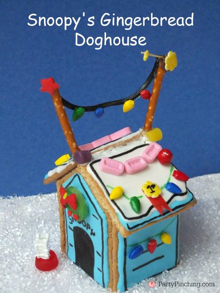 a gingerbread doghouse is decorated with icing and christmas lights