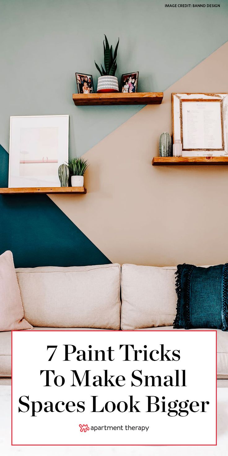 a living room with blue and pink walls, white couches and shelves on the wall