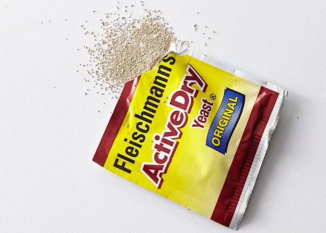 a bag of food sitting on top of a white table next to a pile of seeds