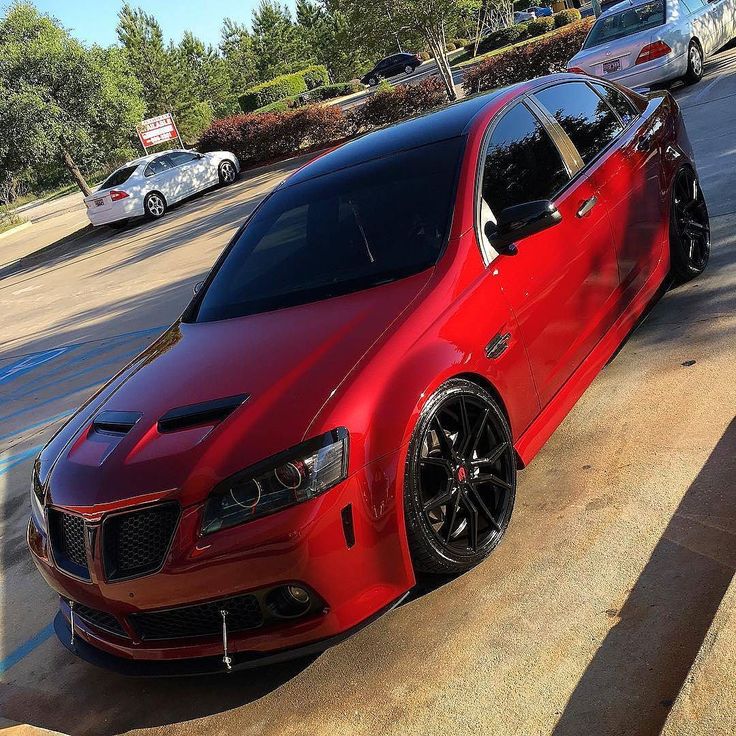 a red car is parked on the street