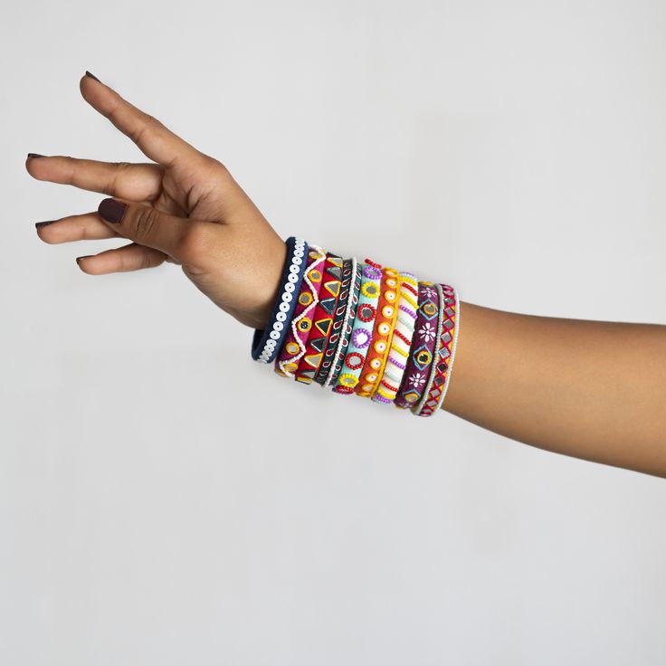 a woman's arm with bracelets on it and her hand extended out to the side