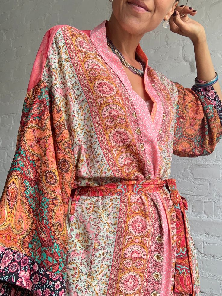 "This is one of a kind patchwork, upcycled silky robe Made free size with wrap tie closing and wide kimono sleeves  Easy and fun to wear around the house or outside as a urban boho style,  flowy kardigan with jeans and tshirt  It is very comfy and feels soft and light  the material is colourful indian saree silk made into this unique stylish over all MEAESURE free size length 55\" MATERIAL *polyester and silk * no lining more avaialable at  https://www.etsy.com/shop/AltheaStores? CARE INSTRUCTIO Multicolor Wrap Kimono For Festivals, Hippie Multicolor Open Front Kimono, Hippie Style Multicolor Wrap Kimono, Colorful Summer Kimono With Kimono Sleeves, Patchwork Kimono For Summer Festivals, Pink Wrap Kimono In Bohemian Style, Pink Hippie Kimono For Summer, Hippie Patchwork Kimono For Spring, Spring Festival Kimono With Patchwork