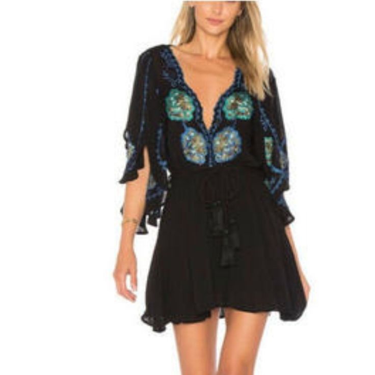 Take A Walk On The Wild Side With The Free People Cora Black Embroidered Dress! Intricate Navy Blue, Teal, And Olive Green Embroidery Decorates This Flirty Woven Dress With A Scalloped, Plunging Neckline And Wide, Fluttering Sleeves With Side Slits. Elastic Waistband, And An Tasseled, Wrap Belt Tops A Leg-Baring Mini Skirt. Skirt Is Lined. 100% Viscose. Machine Wash Cold. Black Embroidered Beach Dress For Spring, Spring Beach Black Embroidered Dress, Spring Beach Embroidered Black Dress, Black Embroidered V-neck Mini Dress, Black Embroidered Mini Dress For Summer, Black Long Sleeve Embroidered Beach Dress, Bohemian V-neck Embellished Mini Dress, Black Floral Embroidered Beach Dress, Beach Black Embroidered Dress With Floral Details