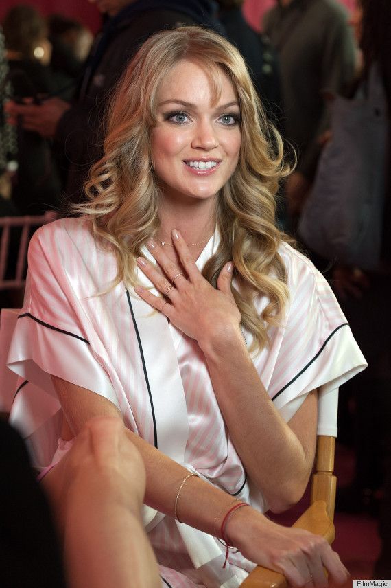 a woman sitting in a chair with her hands on her chest