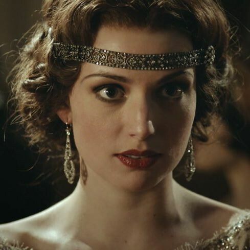 a woman wearing a tiara and looking at the camera with an intense look on her face