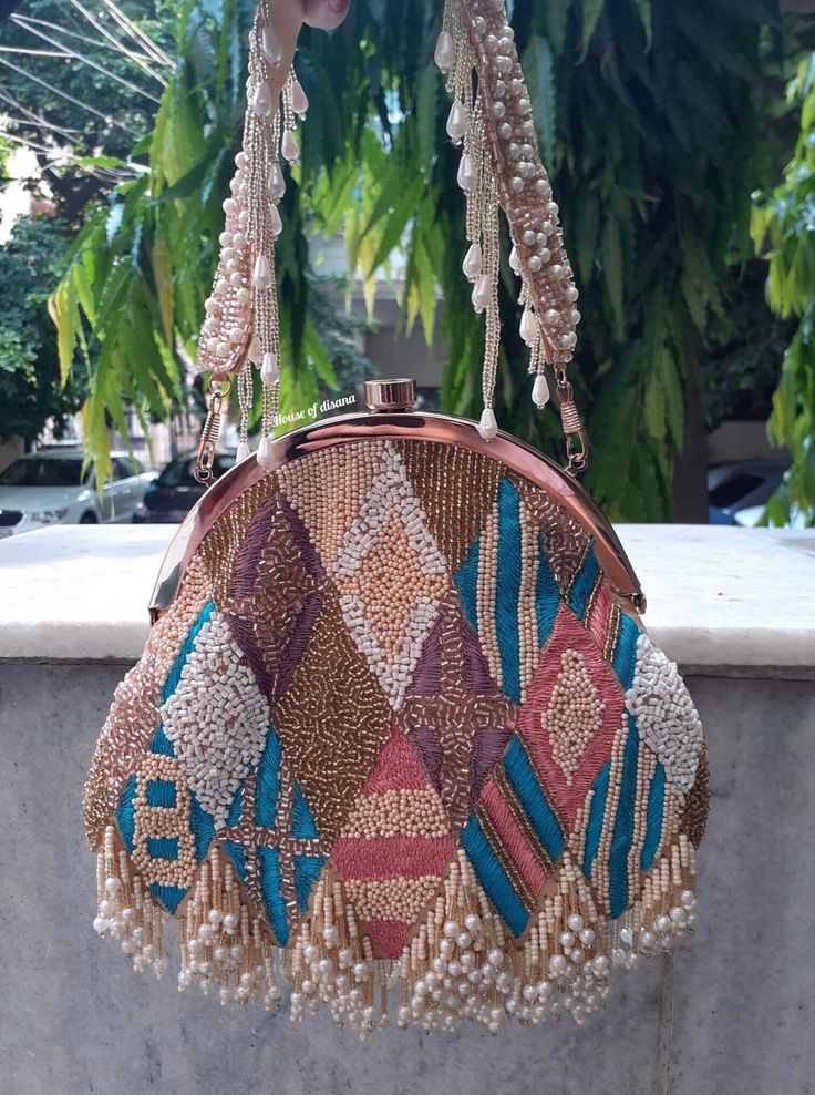 This is a beautiful handcrafted batua bag made with love.It has intricate handwork which showcases the Indian craftsmanship by our local artisans. It comes with a matching handwork handle Details  - Both side handwork  - Fabric lining on the inside to keep your belongings safe  - Magnetic lock closure  - Detachable handle This clutch can be worn as a crossbody bag or a shoulder bag with the sling chain or can simply be carried in hand.It is spacious enough to carry mobile phones, lipsticks, Keys Elegant Party Potli Bag With Openable Design, Elegant Openable Potli Bag For Parties, Elegant Festive Openable Potli Bag, Handmade Handheld Evening Bag For Festive Occasions, Handmade Clutch For Reception And Festivals, Wedding Clutch Bag With Mirror Work, Festive Party Potli Bag With Openable Detail, Openable Potli Bag For Party, Festive Openable Potli Bag For Parties