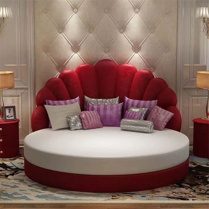 a round bed with many pillows on it