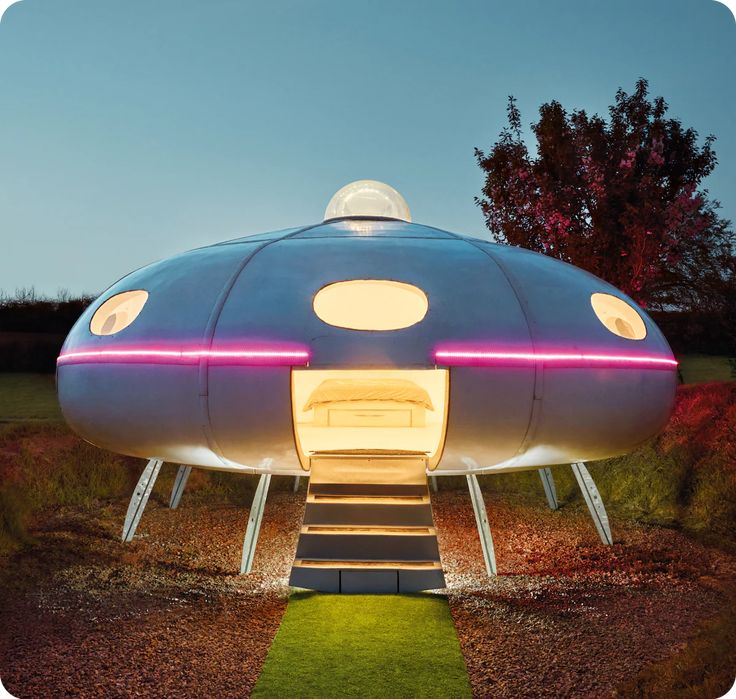 a futuristic house with stairs leading up to the roof and lights on it's sides