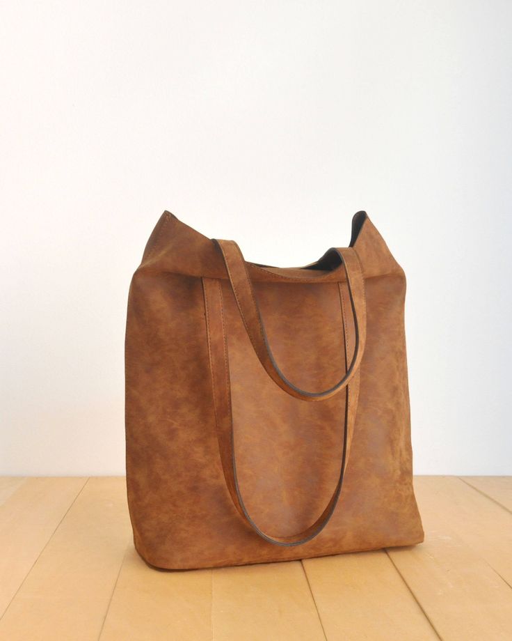 "This tote bag is made of high quality vegan leather in brown. It is soft and lightweight but durable. It has a rustic, distressed look. It has two interior pockets. It has a slouchy silhouette and plenty of room for your daily needs. Measurements: 41 x 31 x 14 cm IMPORTANT! Your orders between 7-25 August will be shipped on August 28. Delivery takes 2-5 days to the US, Canada, Australia and Europe; in 3-7 days to rest of the world after shipping. For other color options you can check \"Totes\" Brown Daily Bag With Adjustable Strap, Brown Daily Bags With Adjustable Strap, Versatile Square Brown Hobo Bag, Leather Softback Shoulder Bag For On-the-go, Versatile Brown Square Shoulder Bag, Versatile Brown Rectangular Satchel, Everyday Recycled Leather Shoulder Bag, Versatile Everyday Brown Bag, Everyday Faux Leather Rectangular Shoulder Bag