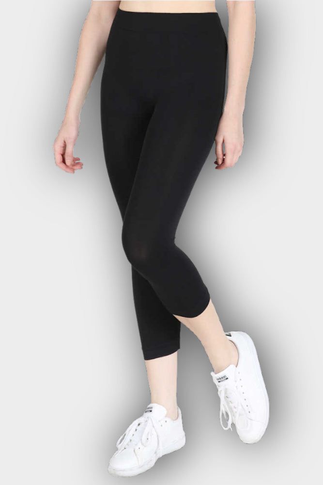 NIKIBIKI's Capri Legging is a super stretchy lightweight nylon legging. This legging has a 2" reinforced waistband and hemmed bottom. Capri length, this leggings falls under the knees to about mid-shin when wearing. Comfortable to wear as a layering piece under tunics and/or dresses, and also as an extra layer for warmth during the cooler months. While this is opaque and not see-through, it is a true layering/accessory garment, not to be worn alone. Made in a flat nylon jersey, not ribbed. No co Casual Black Seamless Leggings, Casual Black Seamless Tights, Casual Compression Leggings With Elastic Waistband, Sporty Elastic Solid Color Leggings, Full-length Elastic Athleisure Tights, Elastic Seamless Leggings, Casual Compression Tights For Pilates, Full Length Elastic Elastane Activewear, Mid-rise Casual Tights For Pilates