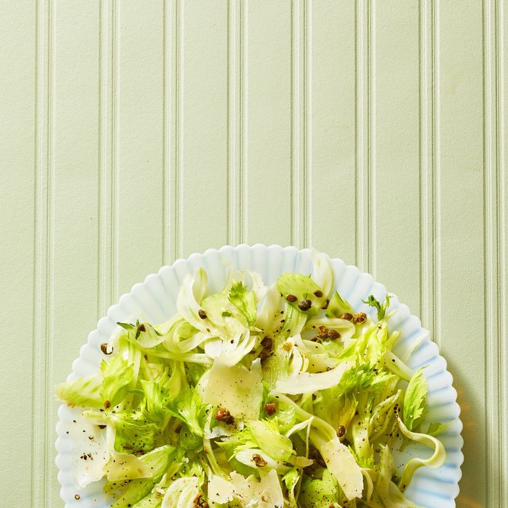 a white bowl filled with lettuce and other vegetables on top of a table