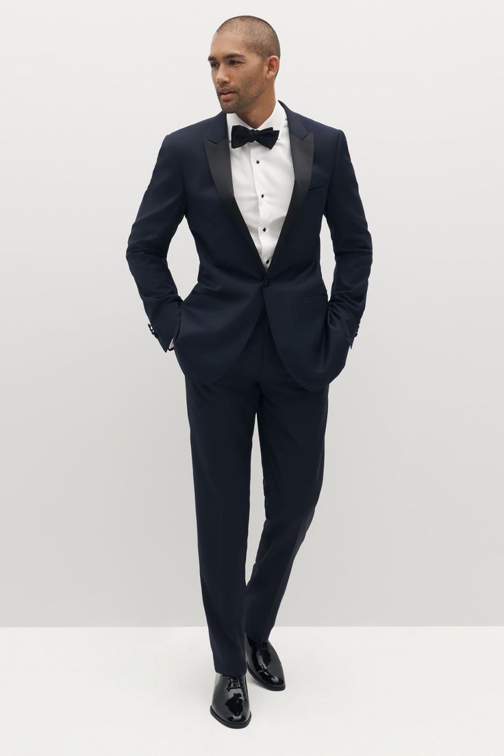 Limited Edition Style: We’ve reached the pinnacle of style with the peak lapel tuxedo, Italian-made and crafted from 100% merino wool. Sleek black, clean design, and an updated lapel come together to bring modern flair to the traditional tuxedo. Satin detailing on the lapel, waistband, and pant seam complete the look. Tuxedo Italian, Dark Blue Wedding Suit, Tuxedo Peak Lapel, Blue Wedding Suit Groom, Traditional Tuxedo, Blue Wedding Suit, Wedding Suit Groom, Peak Lapel Tuxedo, Navy Groom