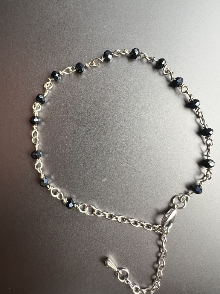 An elegant black glass beads bracelet, measuring 8 inches (11 inches with the extension chain), showcases a sophisticated design. The bracelet features a fancy finish and is adorned with a charming tear drop-shaped metal pendant at the end of the extension chain. The design is an original creation by me. It exudes a touch of sparkle and glamour. ✨ Feel free to customize and adjust the length with the extension chain! 📏 Handcrafted with love and care. Limited stock available! ⚒️ Get yours today and rock this stunning accessory! 💫 Handmade Bracelet Beaded Bracelet Boho Bracelet Gemstone Bracelet Crystal Bracelet Handcrafted Jewelry Personalized Bracelet Charm Bracelet Custom Bracelet Ethnic Bracelet Healing Bracelet Spiritual Bracelet Artisan Bracelet Seed Bead Bracelet Birthstone Bracelet Black Crystal Bracelet With Silver Beads As Gift, Gift Black Crystal Bracelet With Silver Beads, Elegant Beaded Dangle Charm Bracelet, Elegant Metal Beaded Dangle Bracelets, Elegant Black Beaded Charm Bracelet, Elegant Black Hematite Crystal Bracelet, Elegant Hematite Beaded Bracelets With Silver Beads, Elegant Metal Bracelets With Black Beads, Black Charm Bracelet With Lobster Clasp