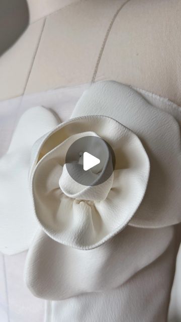 a white flower on the back of a dress with an appliqued center