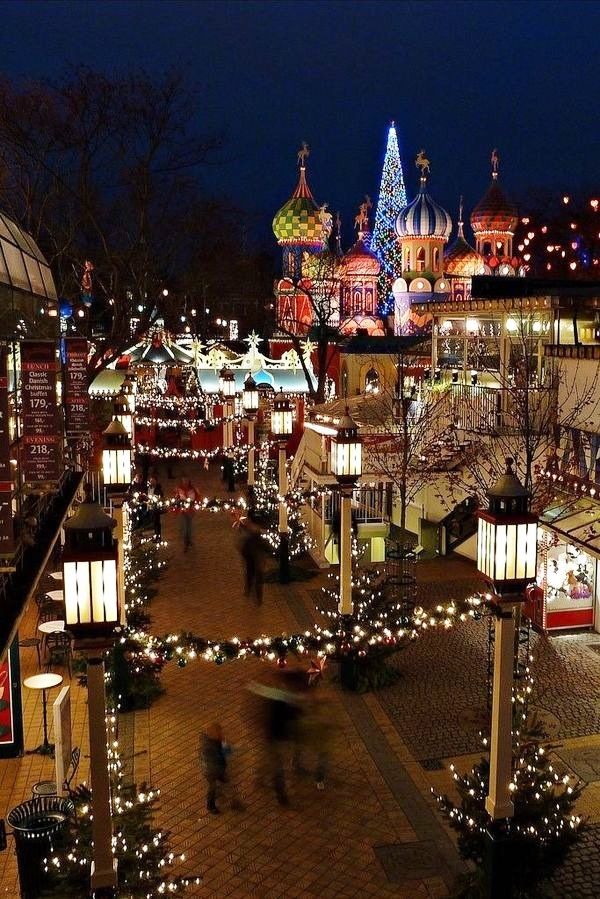 an outdoor christmas market is lit up at night