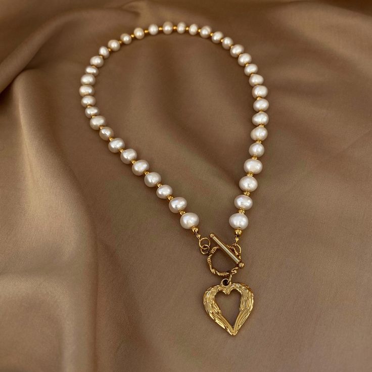 The necklace has an incredibly delicate and romantic design. It is the perfect gift for a woman or a girl, adding softness and a touch of romance to any look. Beads: Natural freshwater pearls and Stainless steel beads. Clasp and Pendant: Stainless Steel. Pendant size: 2cm*2cm. Necklace length 45см. 🔸more from us🔸 https://www.etsy.com/shop/DoraJewelryAccessory Heart Necklace With Pearl Chain For Gift, Heart-shaped Pearl Chain Charm Necklace For Gift, Feminine Necklace With Heart Charm For Gift, Elegant Heart Necklace For Valentine's Day With Lobster Clasp, Handmade Pearl Necklace For Valentine's Day, Pearl Charm Necklace For Valentine's Day Gift, Gold Heart-shaped Pearl Necklace For Gift, Heart-shaped Gold Pearl Necklace For Gift, Heart Pendant Pearl Necklace For Mother's Day Gift