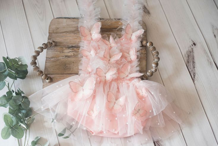 a pink and white dress sitting on top of a wooden table